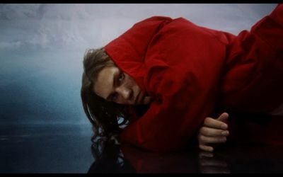 a woman in a red jacket laying on the ground