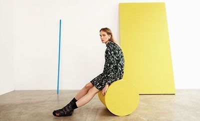 a woman sitting on a yellow object in a room