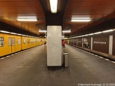 a train station with a yellow train parked next to it