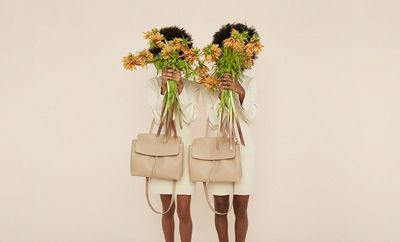 a couple of women standing next to each other holding flowers