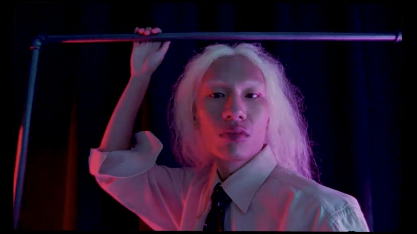 a woman in a white shirt and tie holding a bar