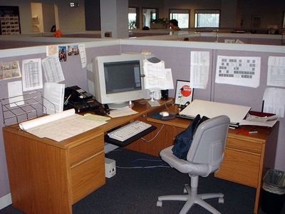 an office cubicle with a desk and computer