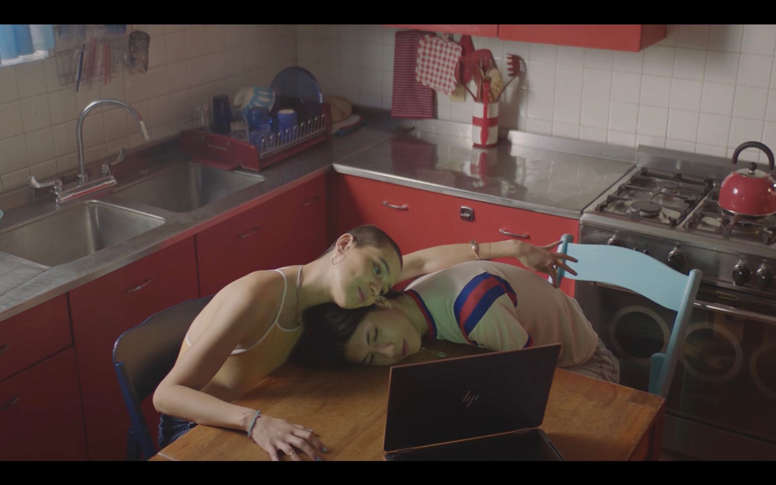 a couple of women laying on top of a wooden table