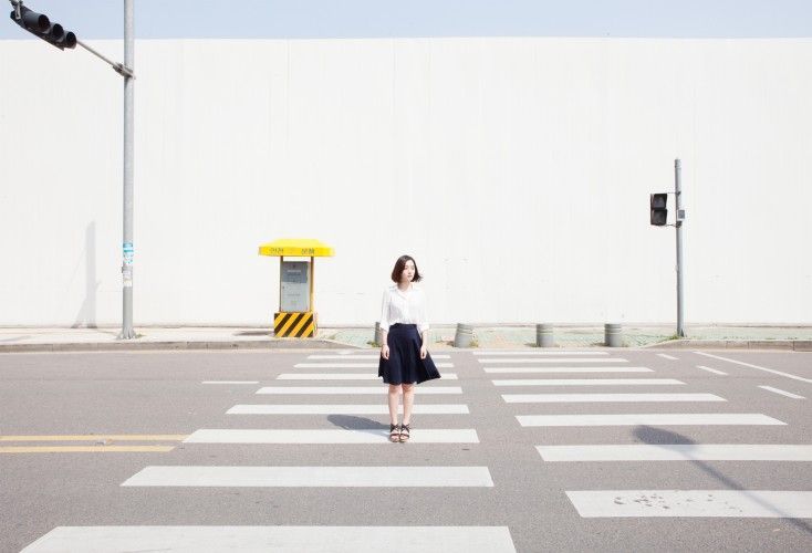 a woman standing in the middle of a cross walk