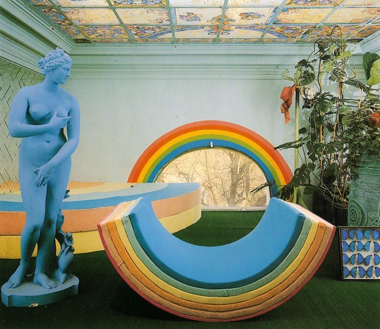 a sculpture of a woman standing next to a rainbow shaped bench