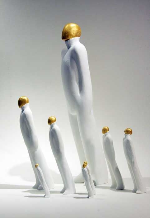 a group of white mannequins with gold accents