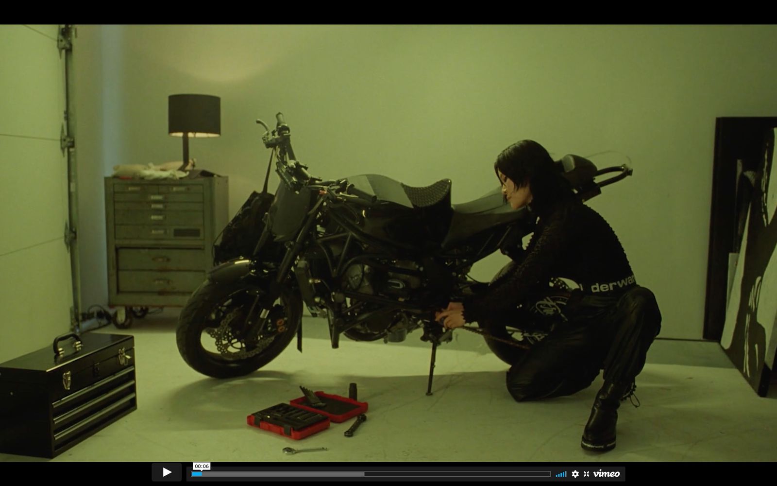 a man kneeling down next to a motorcycle