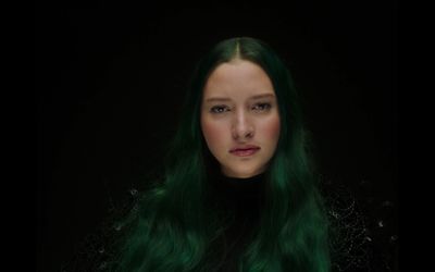 a woman with green hair and a black top