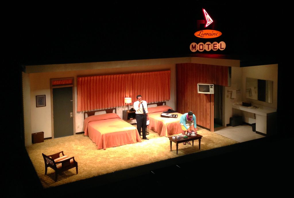 a man standing in front of two beds in a room