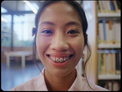 a woman with braces smiles at the camera