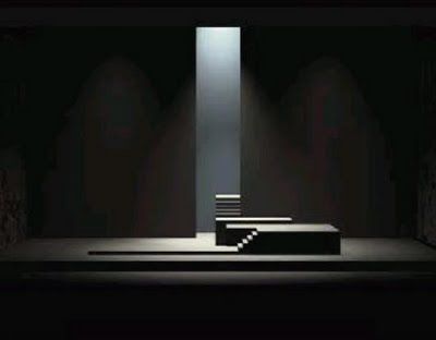 a dark stage with a light at the end of the stage