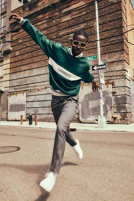 a man in a green sweater is doing a trick on a skateboard