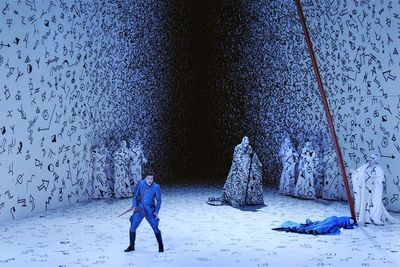 a man standing in front of a wall covered in writing