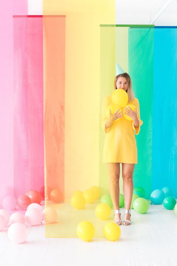 a woman in a yellow dress holding a yellow balloon