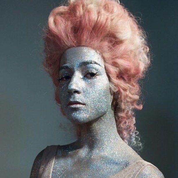 a woman with silver paint on her face and hair