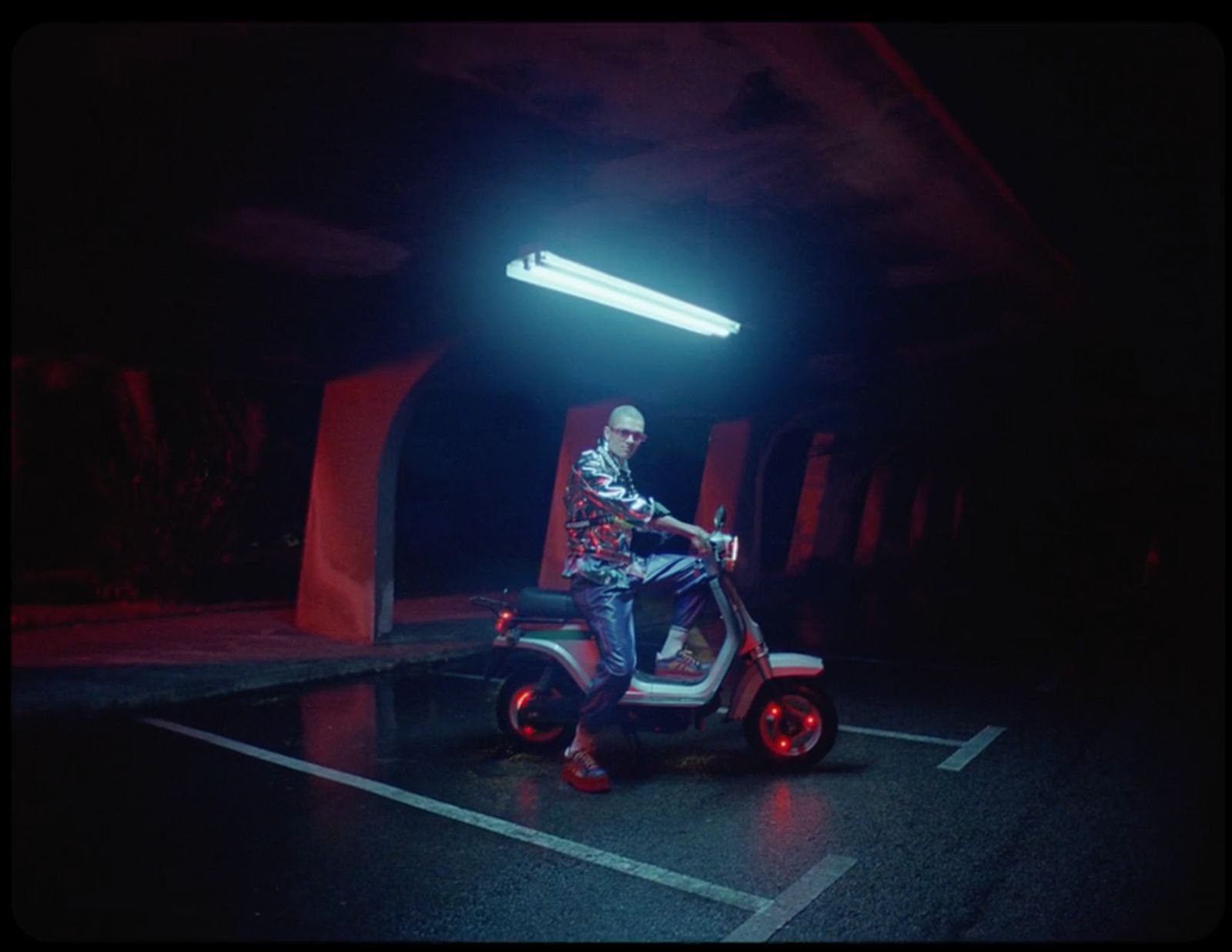 a man riding a scooter in a parking lot