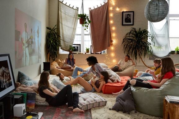 a group of people sitting on bean bags in a living room