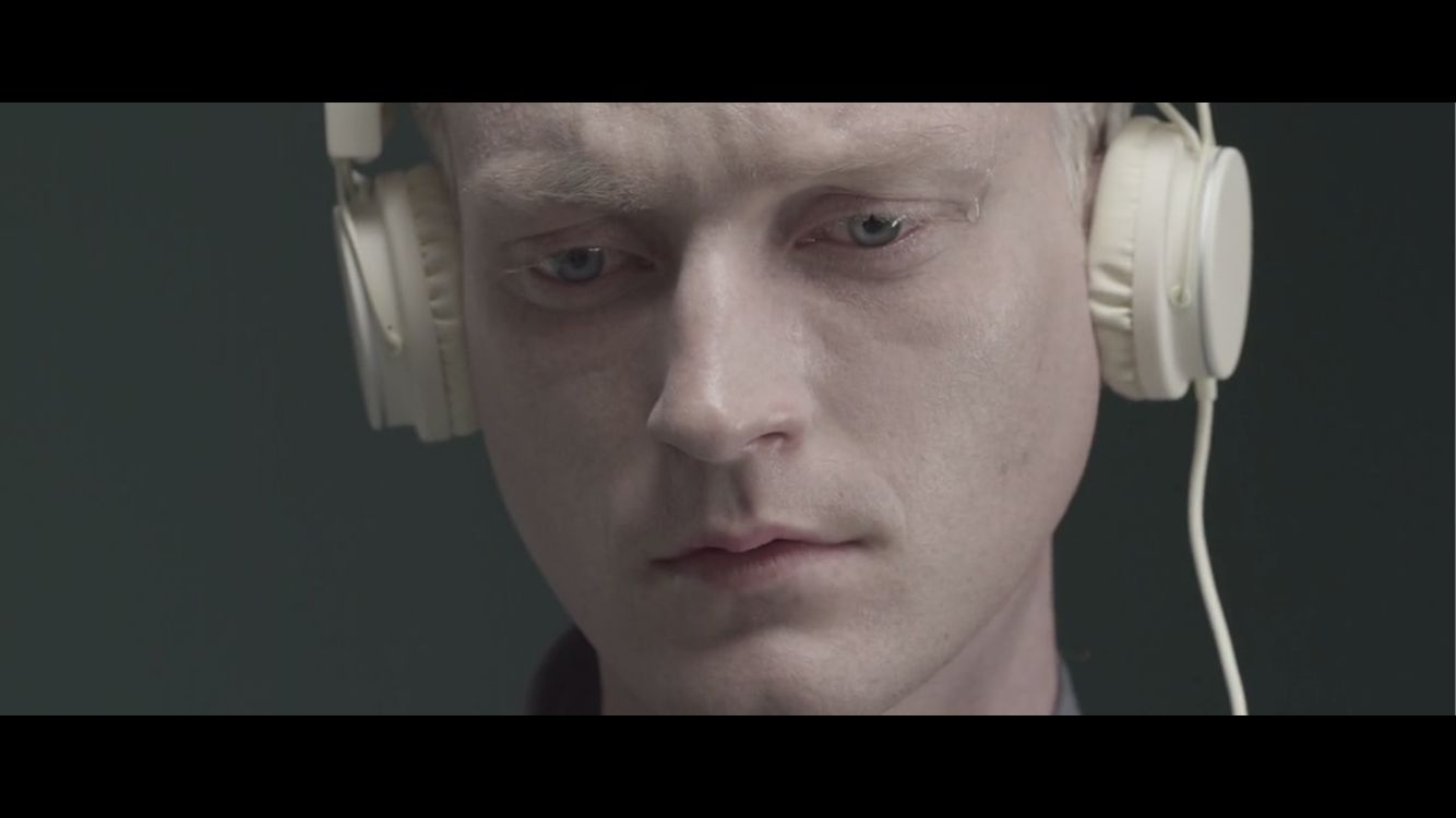 a man with headphones on looking at the camera