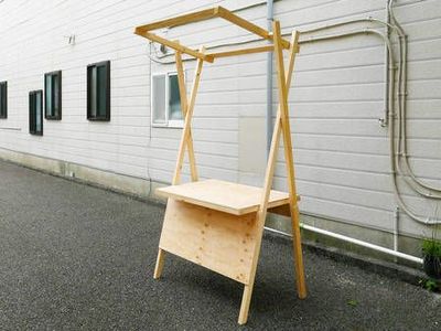 a wooden stand sitting in front of a white building