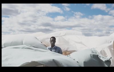 a man standing in front of a pile of bags