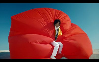 a man sitting on a giant red bean bag chair