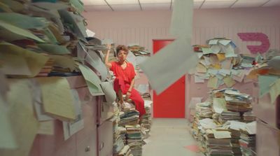 a woman sitting on a stack of files in an office