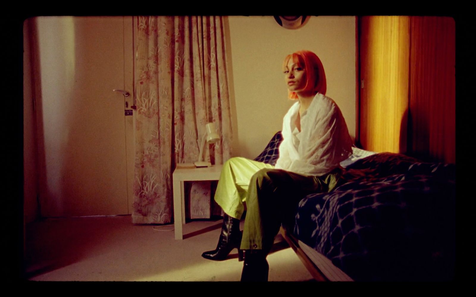 a woman sitting on top of a bed in a bedroom