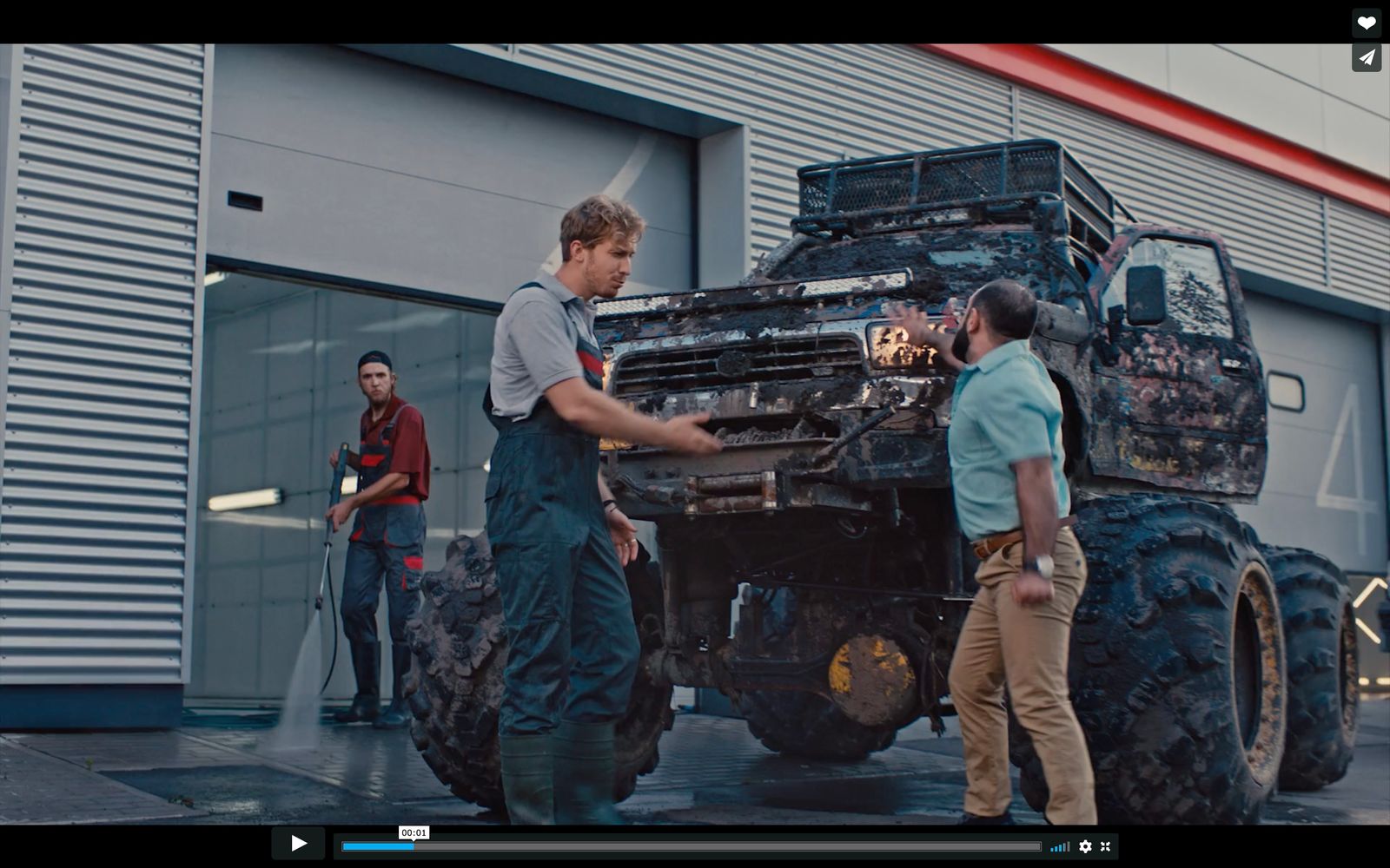 a group of men standing around a monster truck