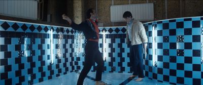 a couple of men standing next to each other in a bathroom
