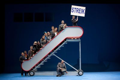 a man sitting on top of a stair case holding a sign