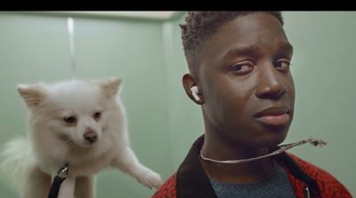 a man holding a white dog up to his face