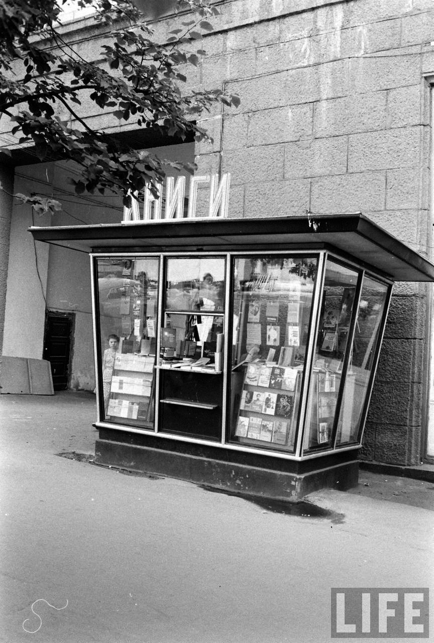 a black and white photo of a newspaper kiosk