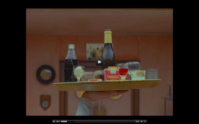 a person holding a tray with bottles and glasses on it