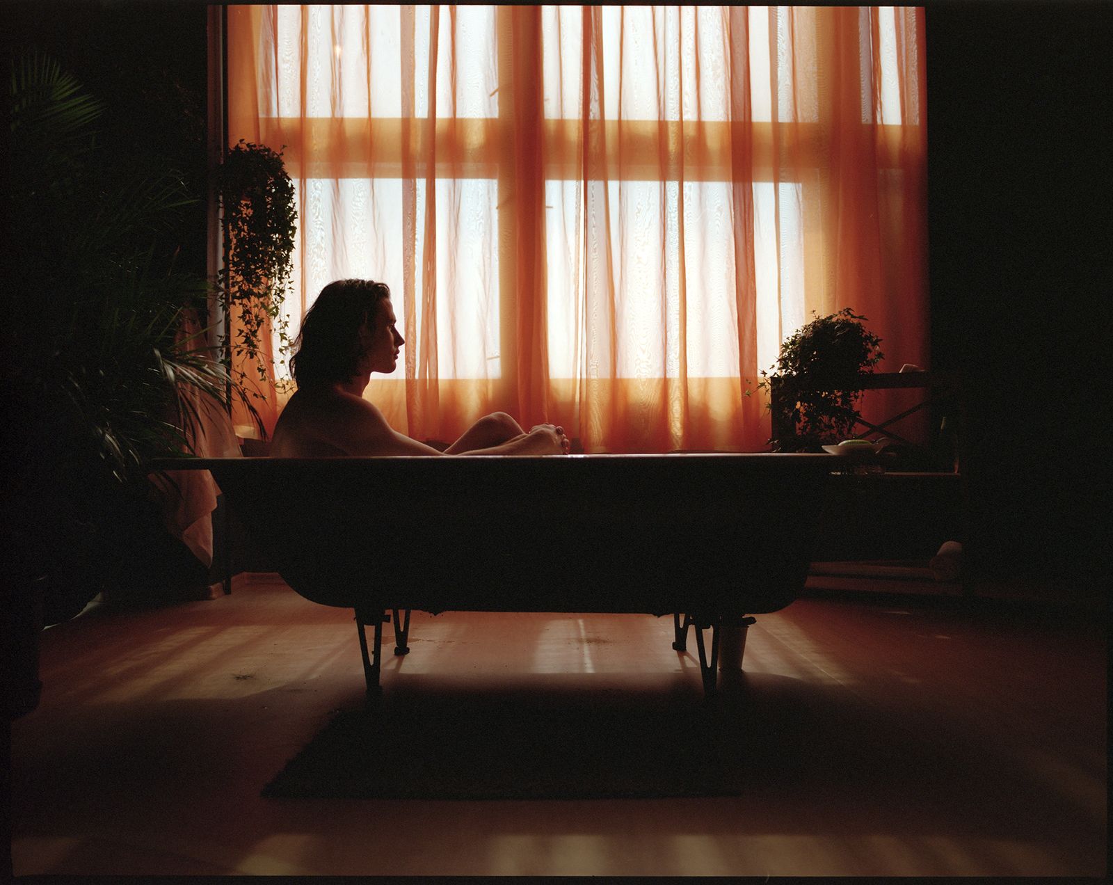 a woman sitting in a bathtub in front of a window