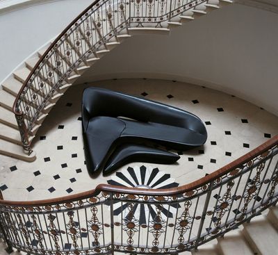 a pair of black shoes sitting on top of a spiral staircase