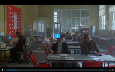 a group of people sitting at desks in a room