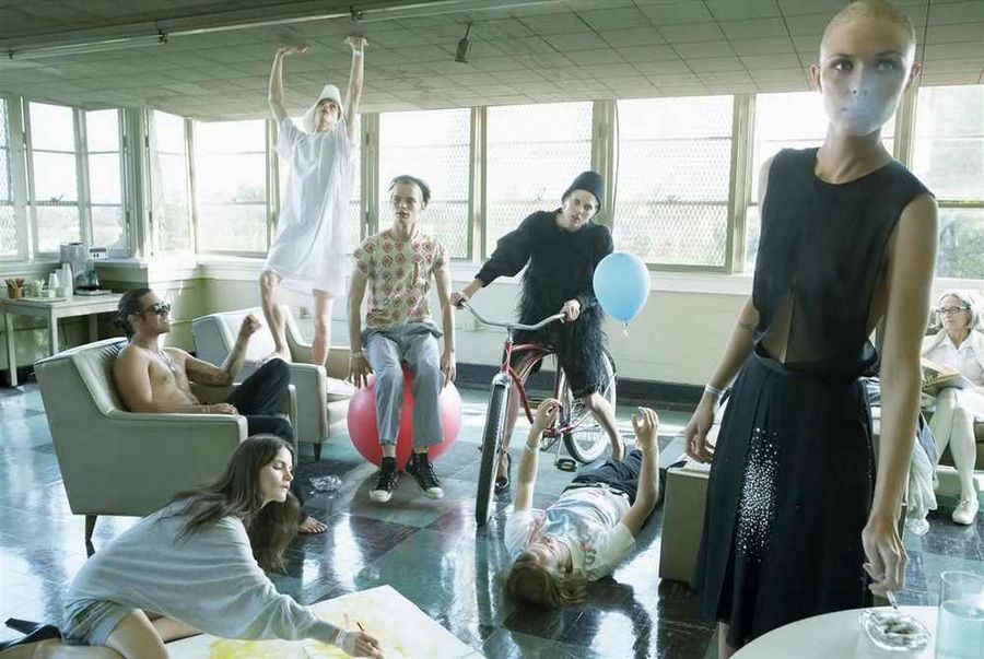 a group of people standing and sitting around a living room