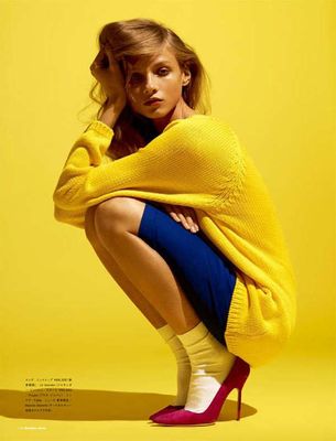 a woman in a yellow sweater and blue skirt