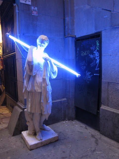 a statue of a man holding a light saber