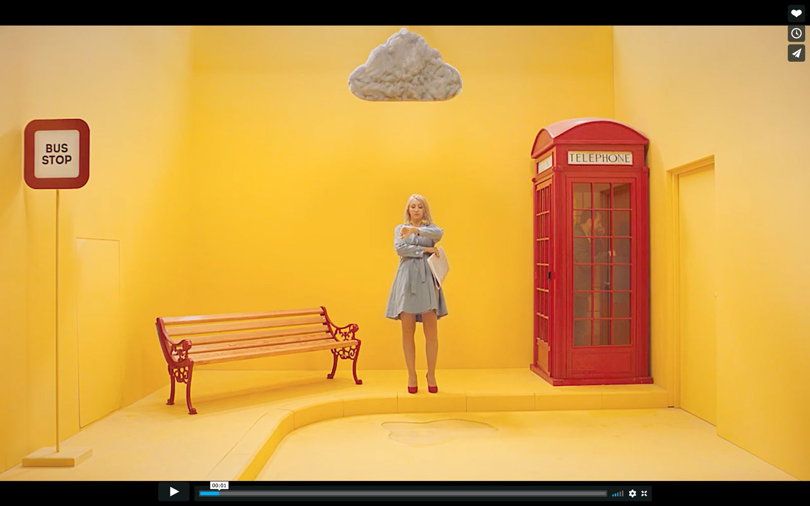 a woman standing in a room with a red phone booth