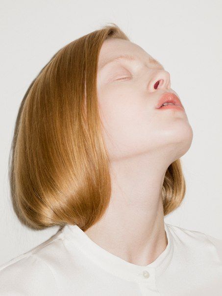 a woman with her eyes closed wearing a white shirt