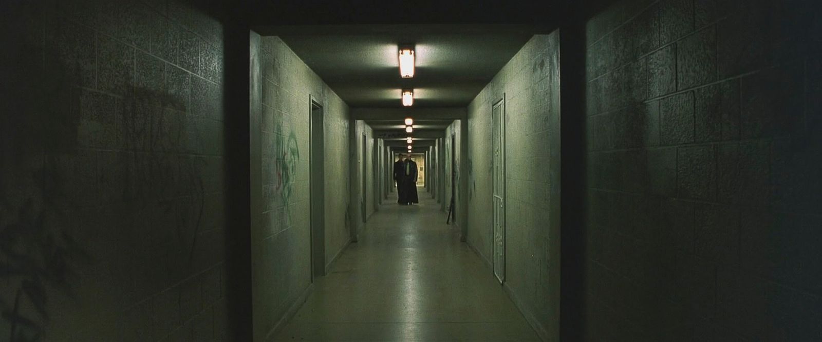 a man is walking down a long hallway