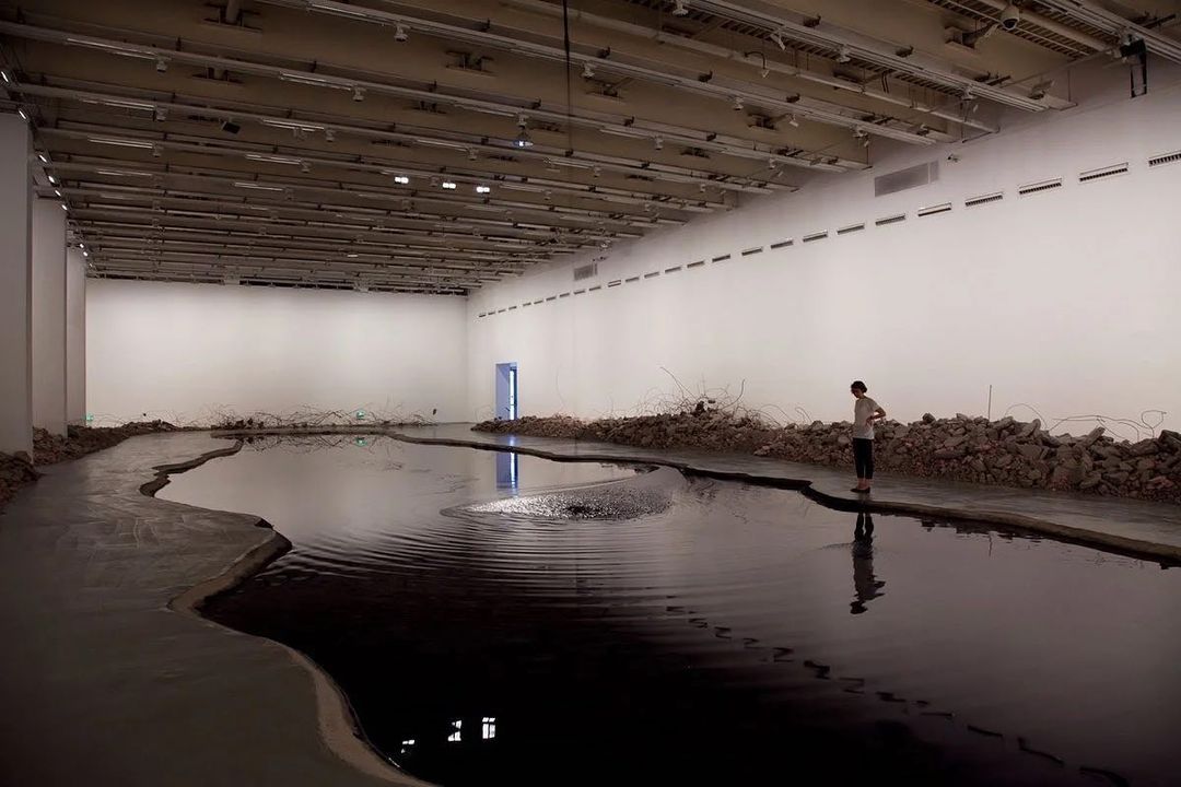 a man standing in a large room with a large puddle of water