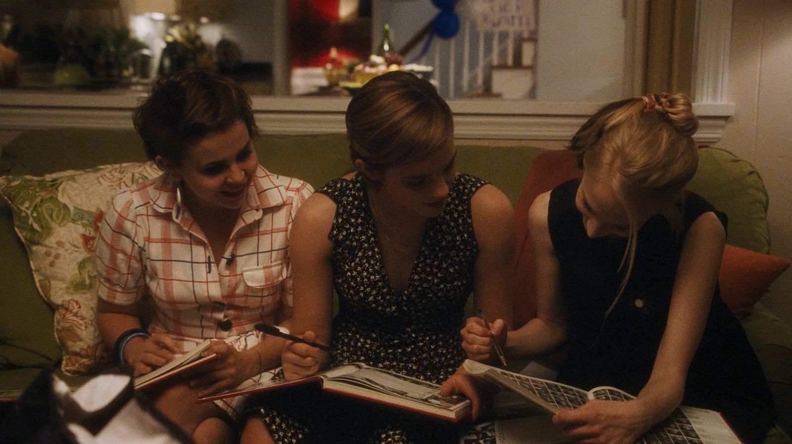 a group of women sitting on top of a green couch