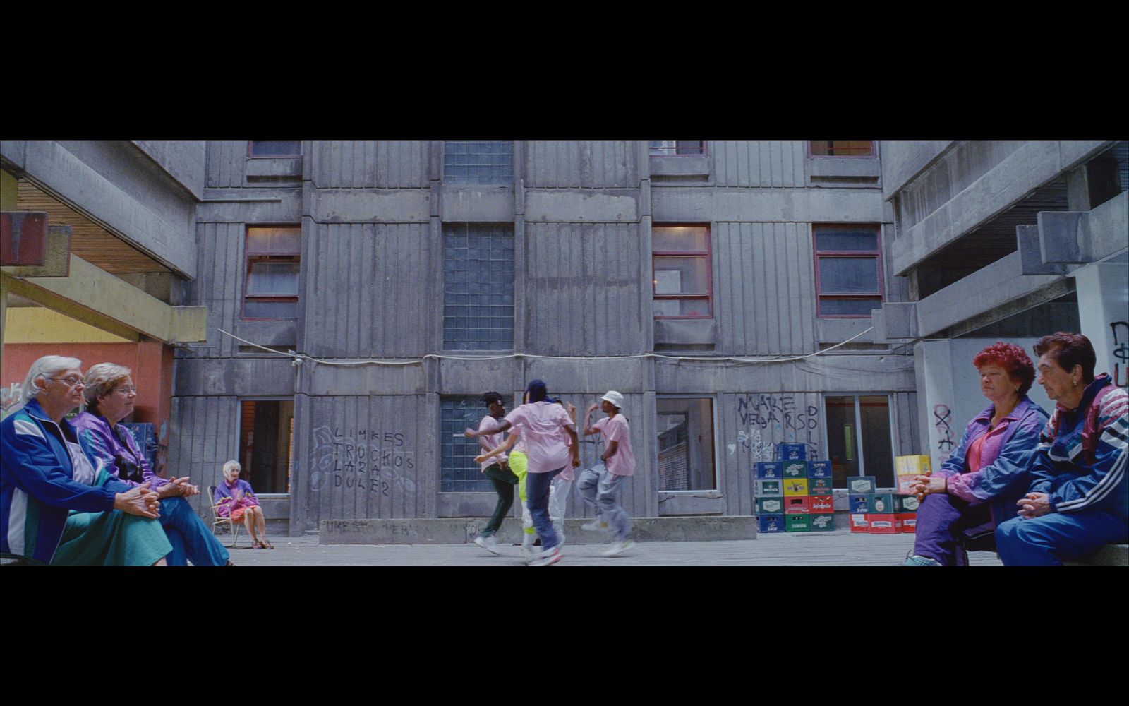 a group of people sitting on a bench in front of a building