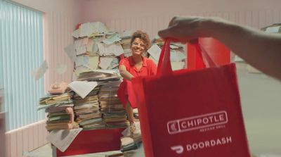 a woman in a red shirt is holding a red bag