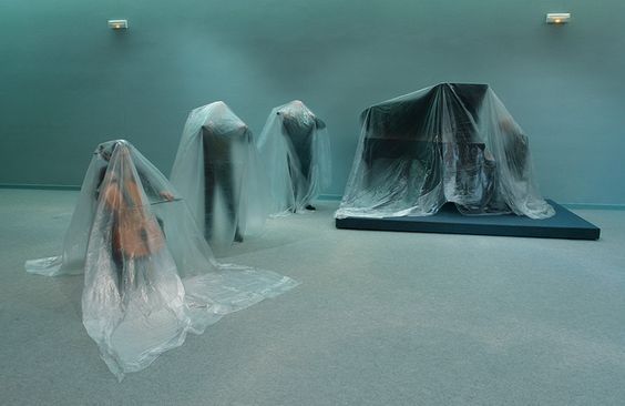 a group of mannequins wrapped in plastic in a room