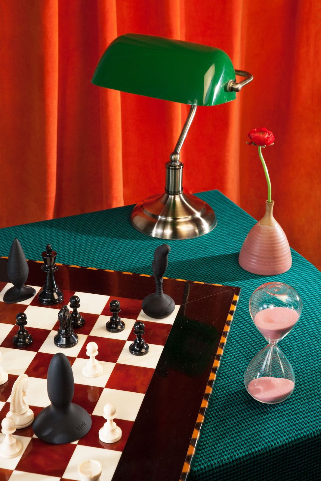 a green table lamp sitting on top of a chess board