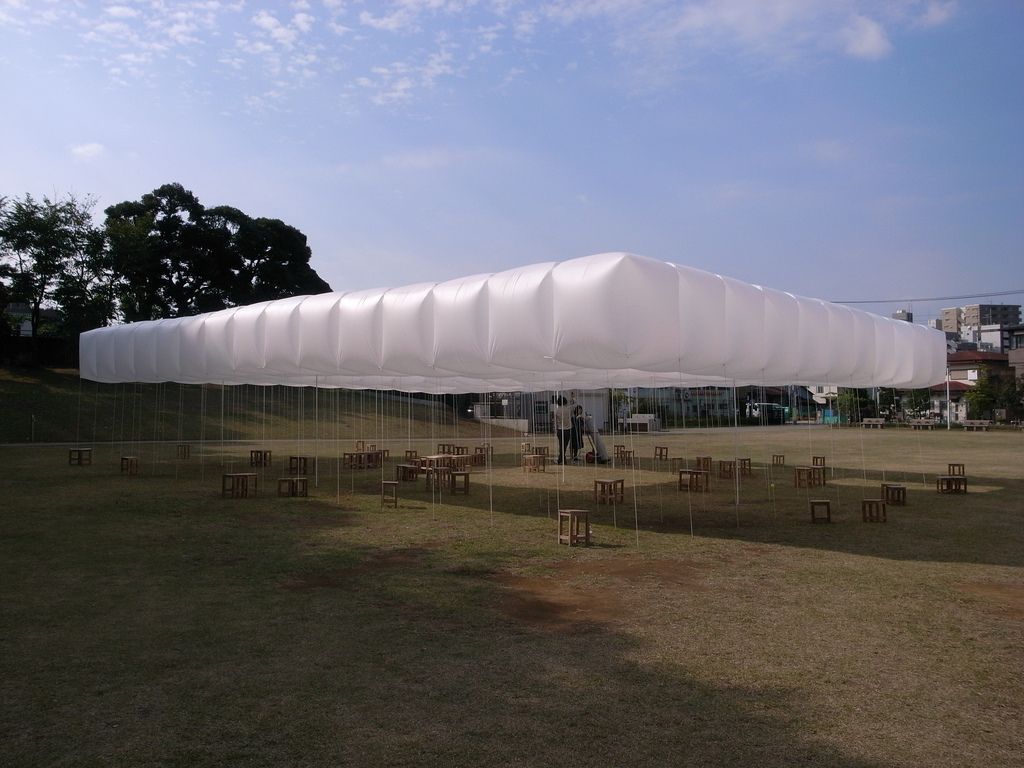 a large white tent sitting on top of a lush green field