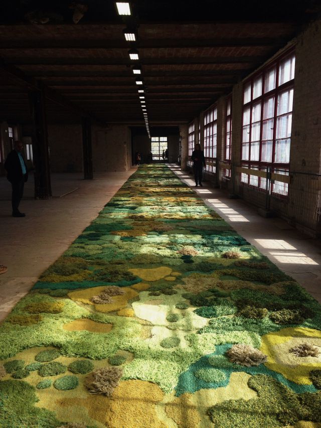 a long hallway with a carpet covered in green and yellow flowers